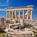 Ancient ruins of the Acropolis, with fallen stone columns and modern scaffolding inside the Parthenon